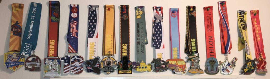 Pat Johnson prepared for her first sprint triathlon at age 70 in less than 30 days. Since then, she has created a collection of finisher medals.  Included is one from Pat's first sprint triathlon.