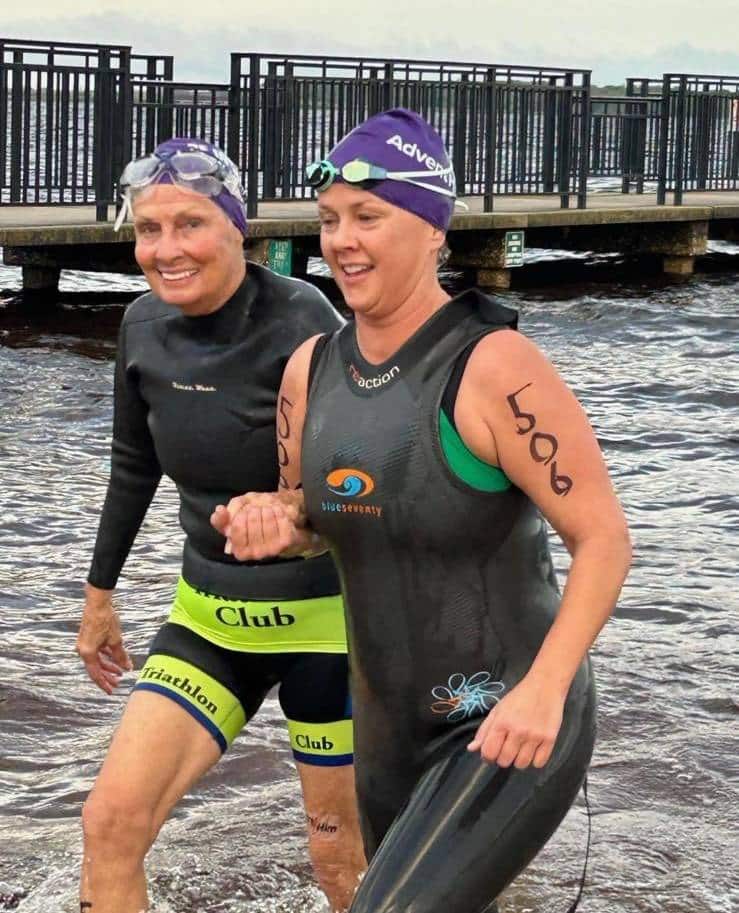 Pat Johnson, age 80, and her niece, Barb, coming out of the water at the Great Clermont Tri in Clermont, Florida. Pat has a wetsuit top over her triathlon suit and Barb and a full length sleeveless wetsuit.