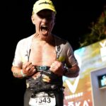 Darrell Myrick at the 2022 Ironman Championship finish line revealing his scar from open heart surgery within the last year