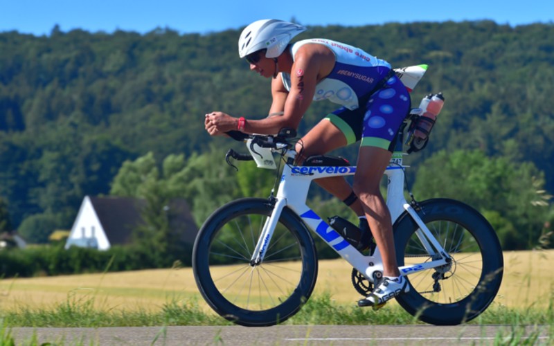 Tony Washington biking in a triathlon. Strength training is key to high performance racing
