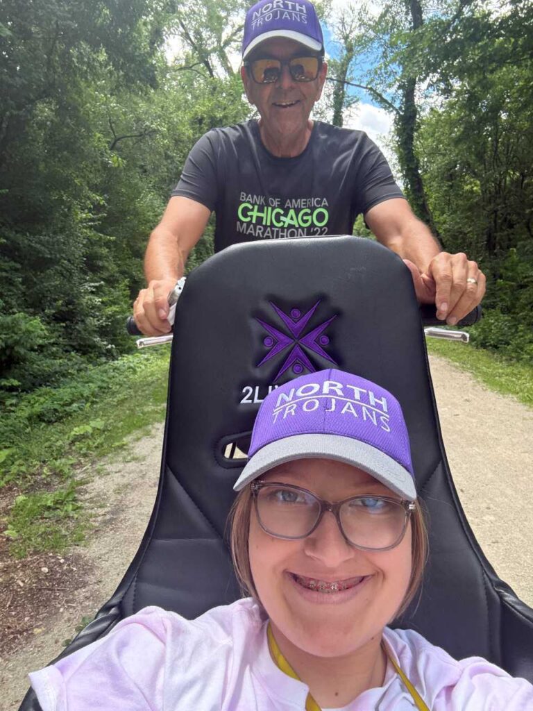 Paul Zenner and granddaughter Addie, both smiling, during a run.